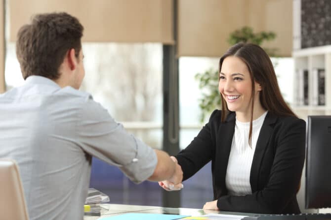 Happy,Businesswoman,Handshaking,With,Client,Closing,Deal,In,An,Office