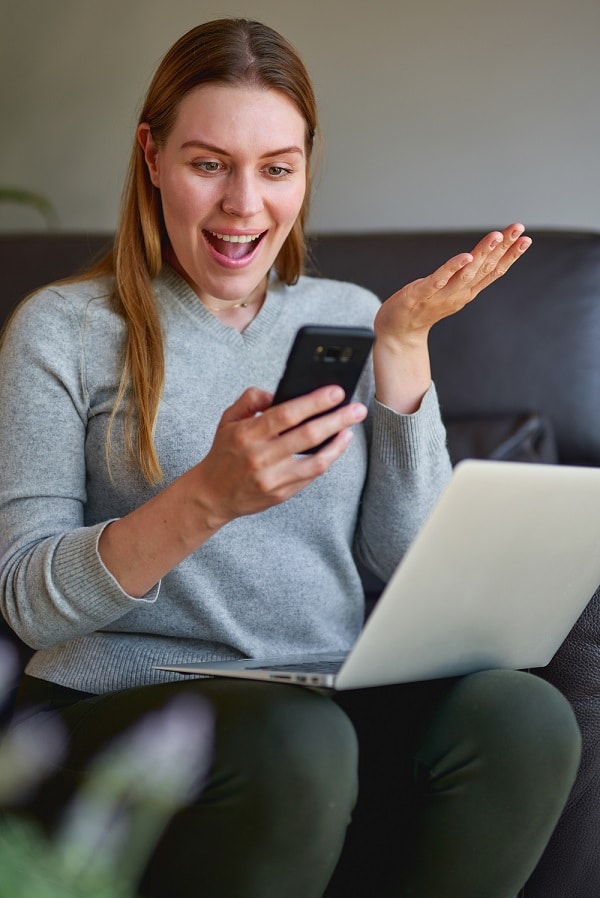 Iloinen nainen selaa älypuhelinta